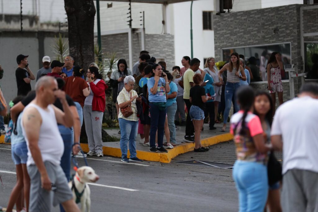  Personas esperan afuera de sus viviendas este miércoles, luego de dos fuertes terremotos que sacudieron el Caribe venezolano en Caracas (Venezuela). El evento principal fue un sismo de magnitud 7,5, informó el sistema oficial de alerta de tsunamis de Estados Unidos. EFE/ Ronald Peña R.